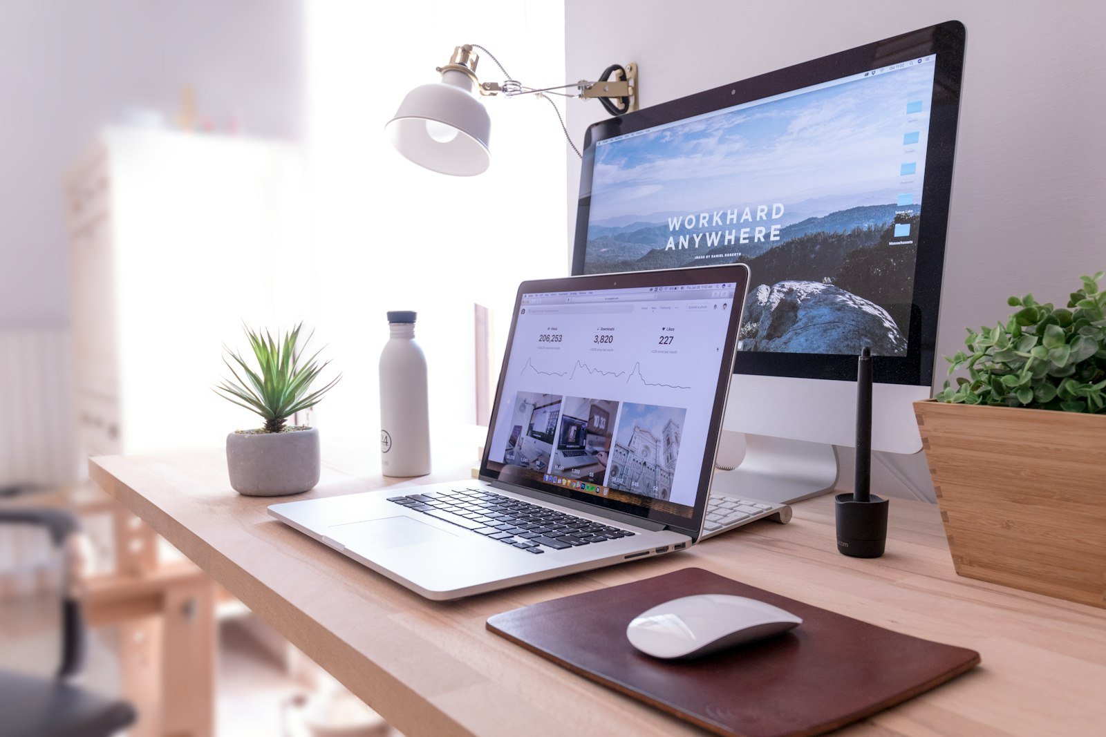 MacBook Pro beside an iMac on a desk, two computers side by side
