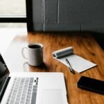 Laptop open on a wooden desk in a bright workspace
