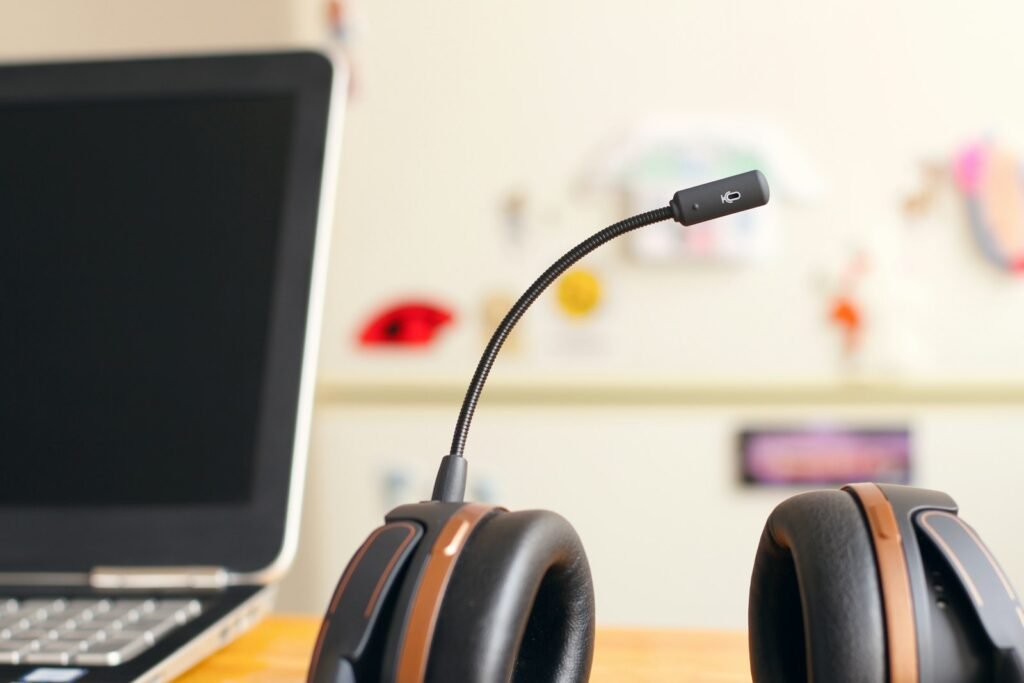 Black and brown headset resting beside a laptop computer