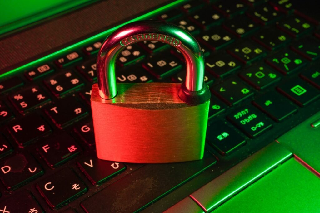 Red padlock resting on a black computer keyboard, representing cyber threat exposure