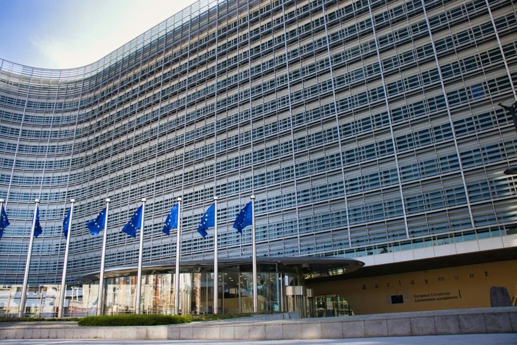 Modern glass building flying European Union flags